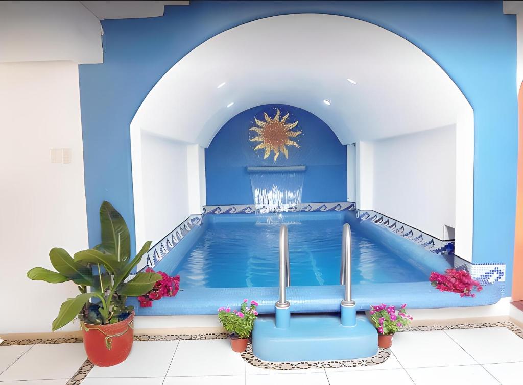 a pool in a blue room with a fountain at Hotel Victoria in Zihuatanejo