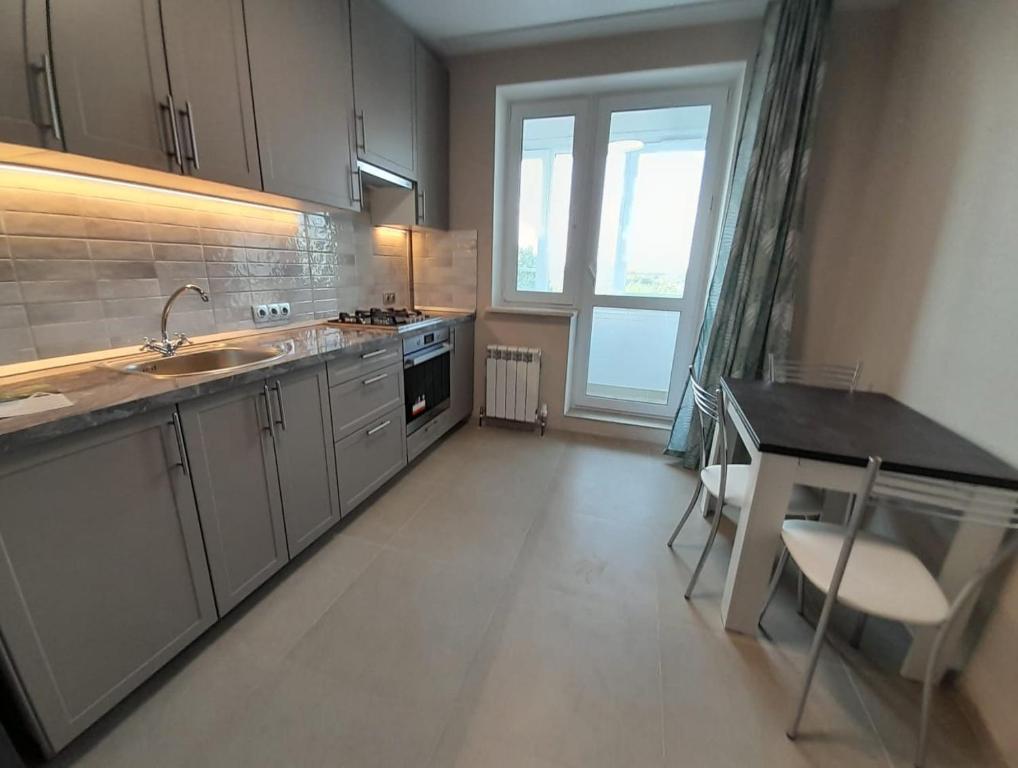 a large kitchen with a sink and a stove at Casa intr-o zona linistita in Bender