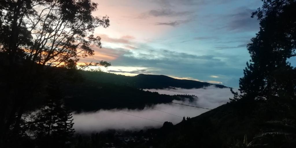 una vista de un valle lleno de nubes al atardecer en Hermosa vista, casa en Boquete., en Boquete