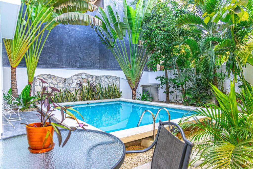 un patio avec une table et des chaises et une piscine dans l'établissement Casa Alegria BY Sandy Powerful, à Tulum
