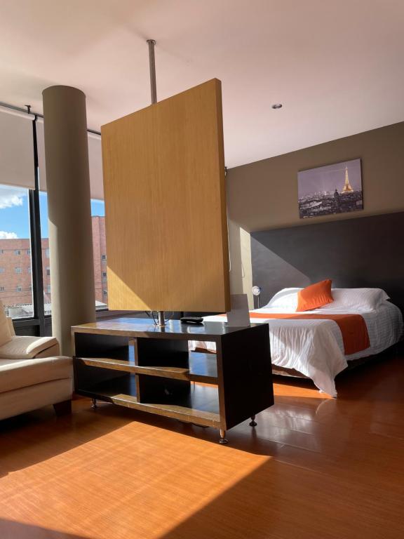 a bedroom with a bed and a dresser with a mirror at Hotel Juliette Bogota in Bogotá