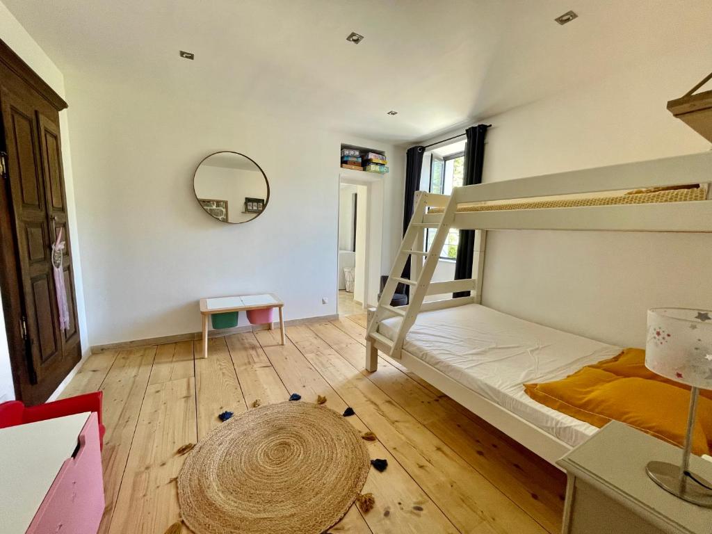 een slaapkamer met een stapelbed en een spiegel bij Casa Arena Authentique maison de village avec piscine au cœur de l’Alta Rocca - Zoza in Zoza