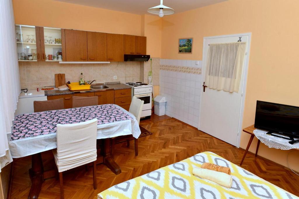 a kitchen with a table and chairs in a room at Štefanija Apartmani in Nedelišće