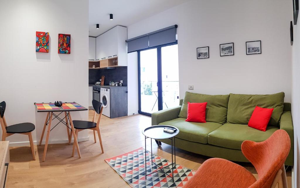 a living room with a green couch and a table at Tirana Central Apartments - Premium in Tirana