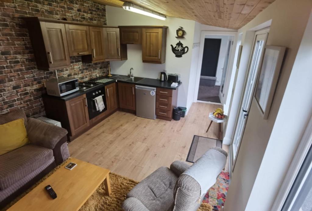 ein Wohnzimmer mit einem Sofa und einer Küche in der Unterkunft The Snug in Letterkenny