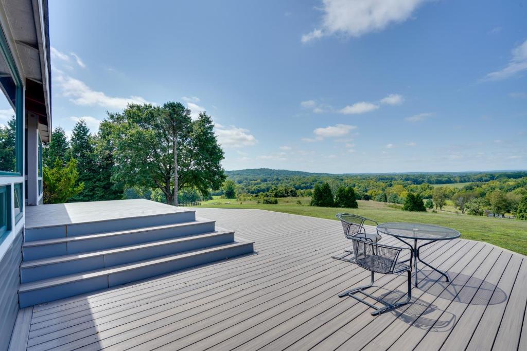 una terraza con mesa y sillas en una casa en Spacious Virginia Retreat with Deck and Scenic Views!, en Leesburg