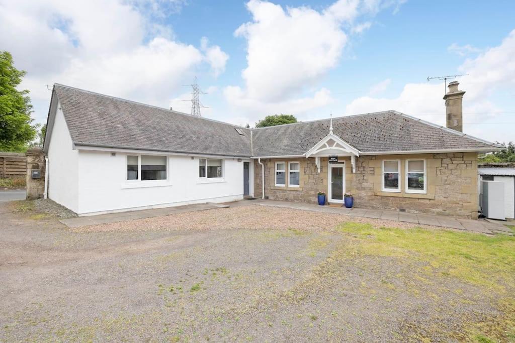 a house with a driveway in front of it at Two Bedroom Country Cottage With Parking in Musselburgh