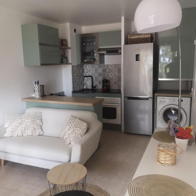 un salon avec un canapé blanc et une cuisine dans l'établissement T 2 à 5 mn à pied de la mer, à Sanary-sur-Mer