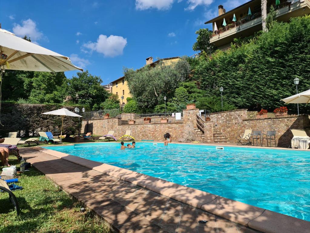 a swimming pool at a resort with people in it at Relax in Chianti IL BORGO 8 in Montespertoli