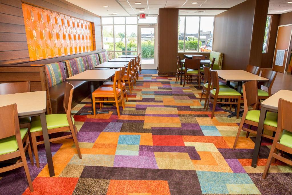 a dining room with tables and chairs on a colorful floor at Fairfield Inn by Marriott Lumberton in Lumberton