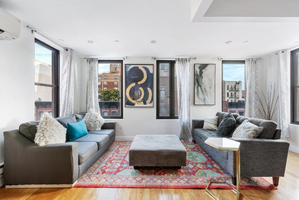 a living room with two couches and a rug at Unique 3BR in NYC in New York