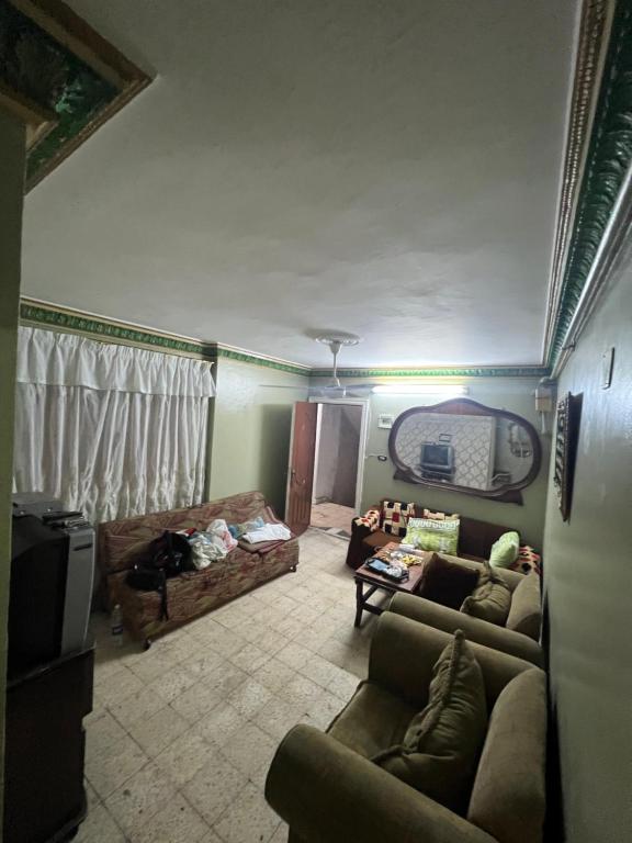 uma sala de estar com dois sofás e uma televisão em شقة مصيف قريبة للبحر في ميامي em Alexandria