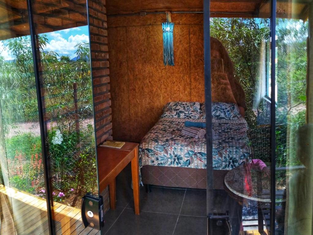 Habitación pequeña con cama y mesa en Casa Raízes Capão, en Vale do Capao