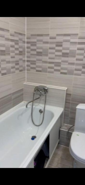 a bathroom with a bath tub with a toilet at casa langa magazine in Floreşti