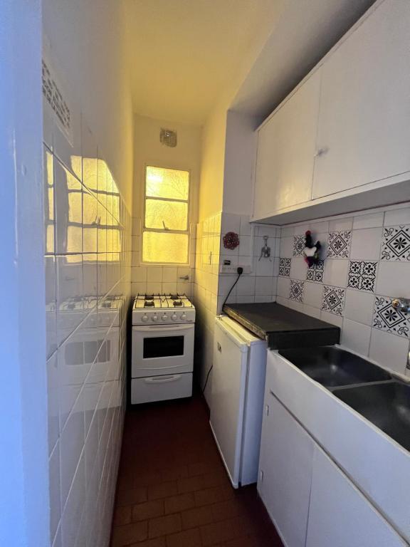 cocina blanca con fogones y fregadero en Hermoso Departamento en Belgrano R para 3 personas en Buenos Aires