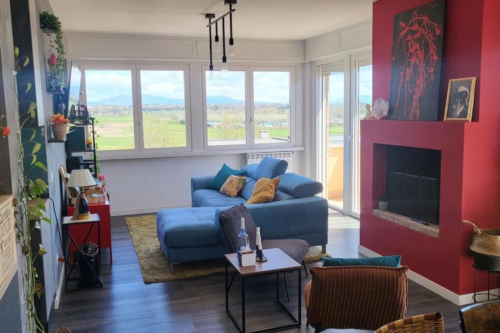 sala de estar con sofá azul y chimenea en Appartamento di Charme vicino al mare, en Torvaianica