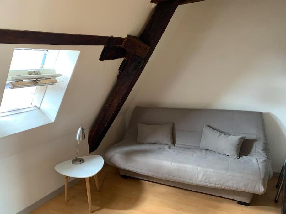 a bedroom with a bed and a table and a window at Le nid d’aigles in Dole