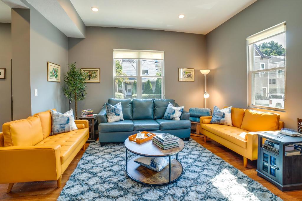 a living room with yellow and blue couches and a table at Family-Friendly Pittsburgh Home about 4 Mi to Downtown in Pittsburgh