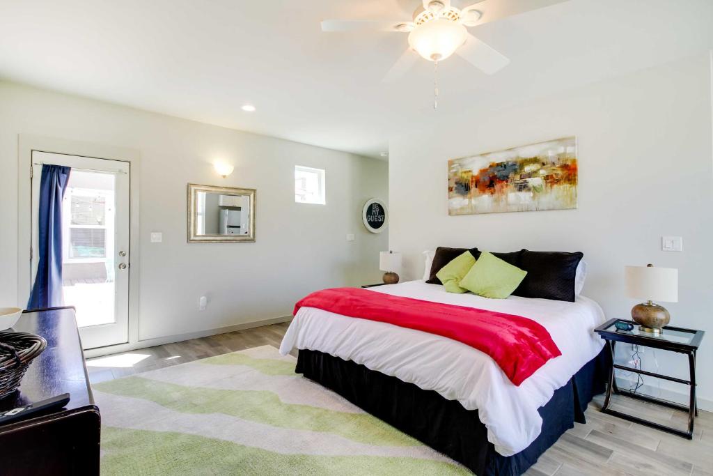 a white bedroom with a large bed with a red blanket at Albuquerque Vacation Rental Less Than 1 Mi to Downtown! in Albuquerque