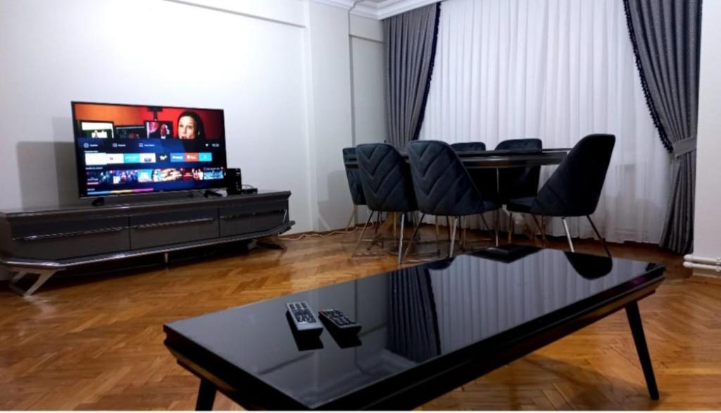 uma sala de estar com uma mesa e cadeiras e uma televisão em Appartement 1er etage Ortaköy No 3 em Istambul