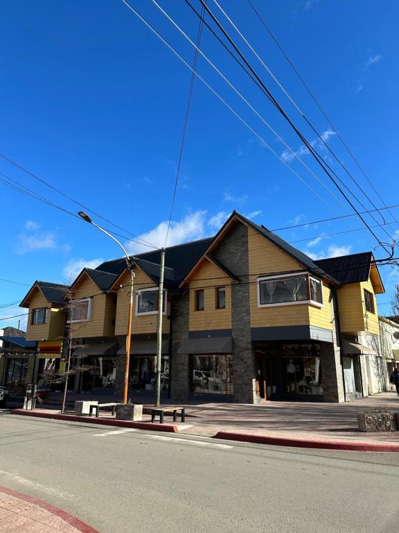 a building on the corner of a street at Los Alerces Patagonia Apart in Esquel