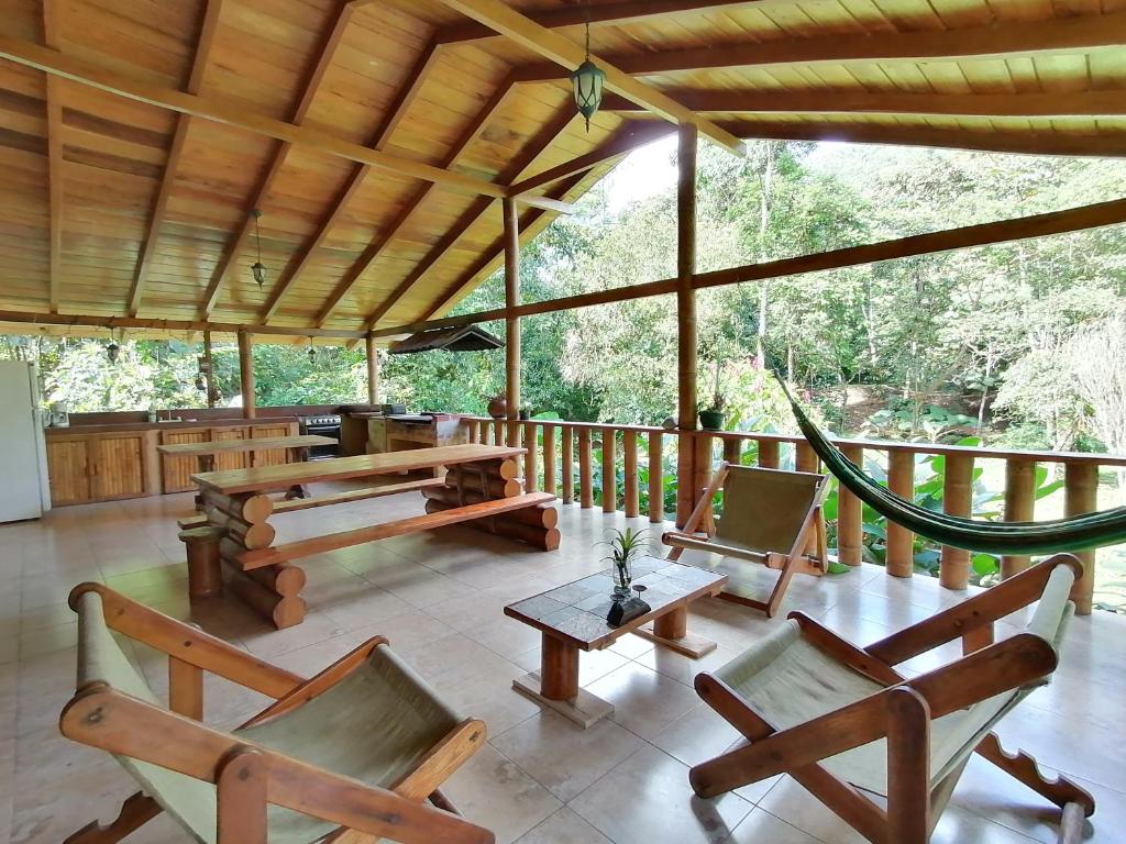un porche con mesas y sillas de madera en La Chonta en Mindo