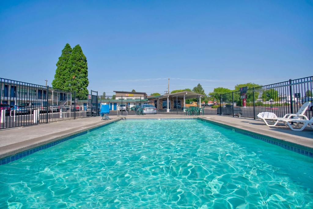 a swimming pool at a resort with two chairs at Motel 6-Bend, OR in Bend