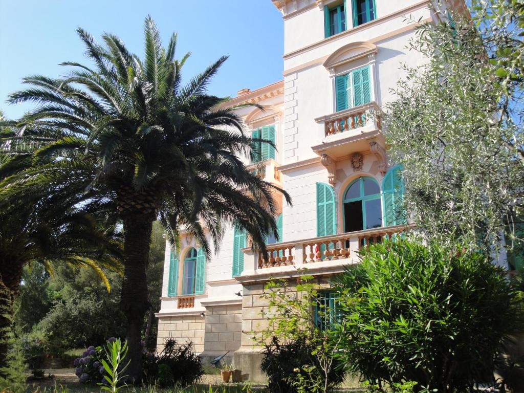 un edificio con una palmera delante de él en Villa Val d'Or, en Saint-Raphaël