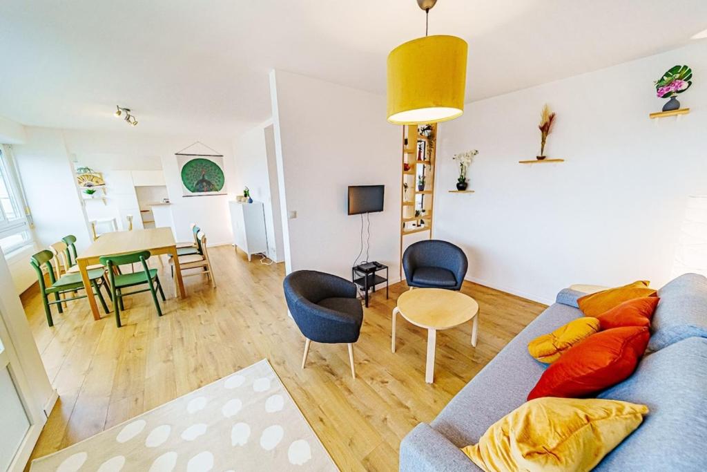 uma sala de estar com um sofá azul e uma mesa em Charmant 2 chambres rénové avec balcon-Oullins em Oullins