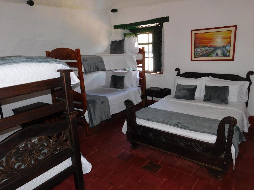 1 dormitorio con 2 literas y ventana en Casa Hotel Paraíso Bella Villa en Villa de Leyva