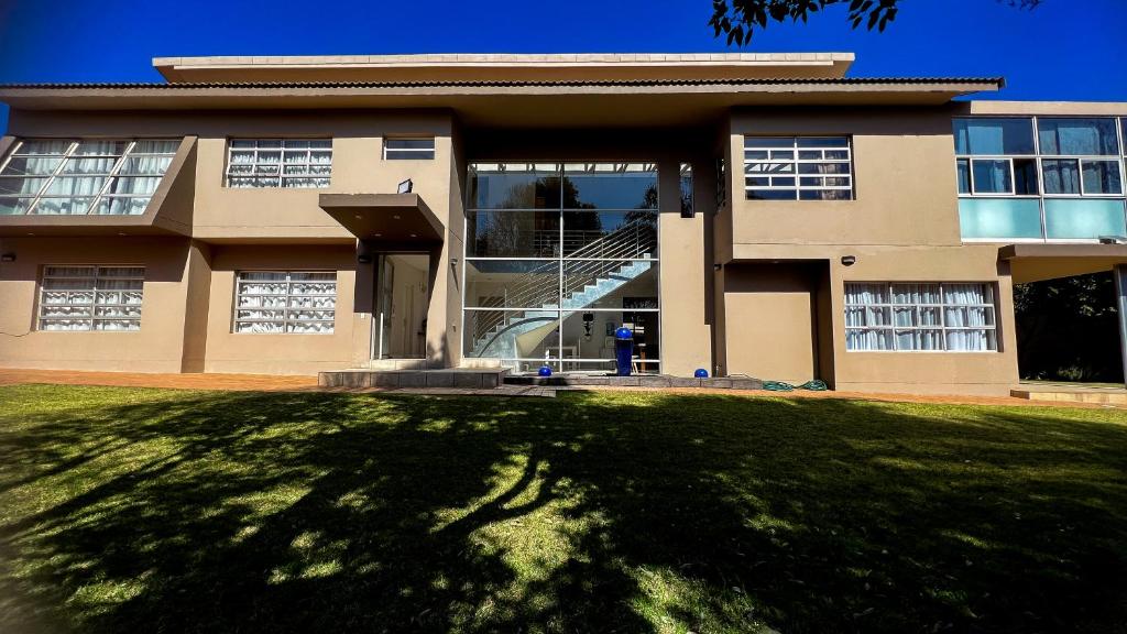 un gran edificio con un gran césped delante de él en Sizanazo Guest House - in the Heart of Northcliff Hill, en Johannesburgo