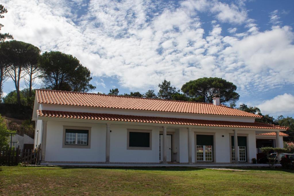 ein kleines weißes Gebäude mit rotem Dach in der Unterkunft Quinta Casal da Eva in Alcobaça