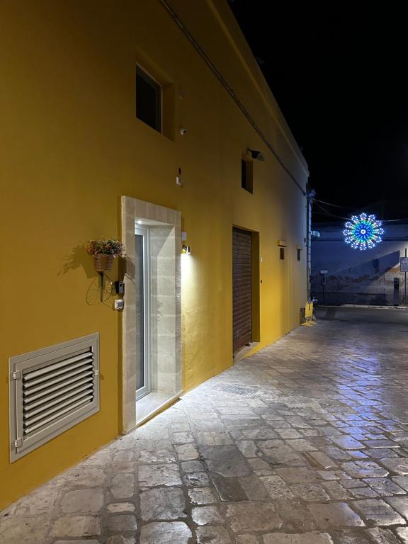 żółta ściana z oknem i budynkiem w obiekcie Castrum Rooms w mieście Mesagne