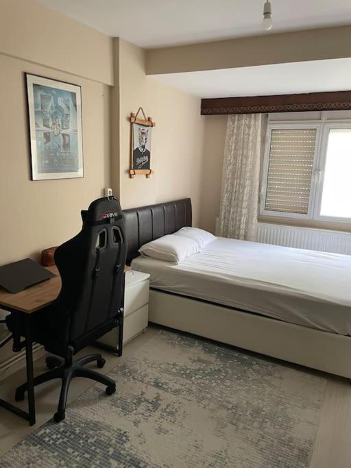 a bedroom with two beds and a desk and a chair at The Room in Karşıyaka