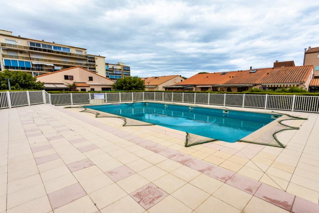 a swimming pool on a tiled floor in a building at Maison conviviale à Argelès-sur-Mer avec piscine partagee 35 m² in Argelès-sur-Mer
