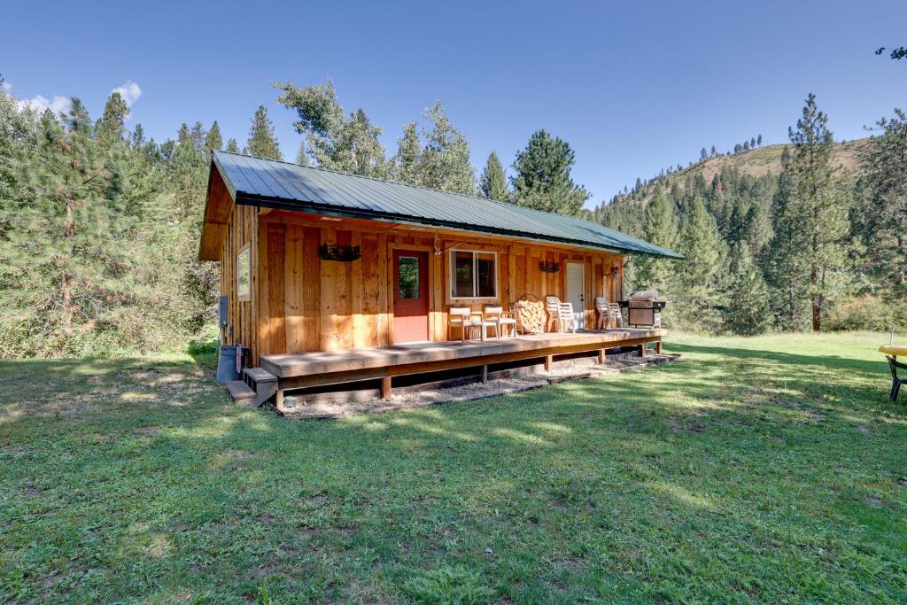 a log cabin with a porch in a field at Cozy Countryside Cabin in Robie Creek Park! in Boise