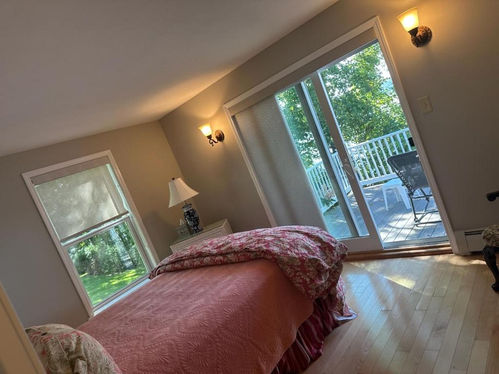 a bedroom with a bed and a large window at Claddagh Cottage in Richfield Springs