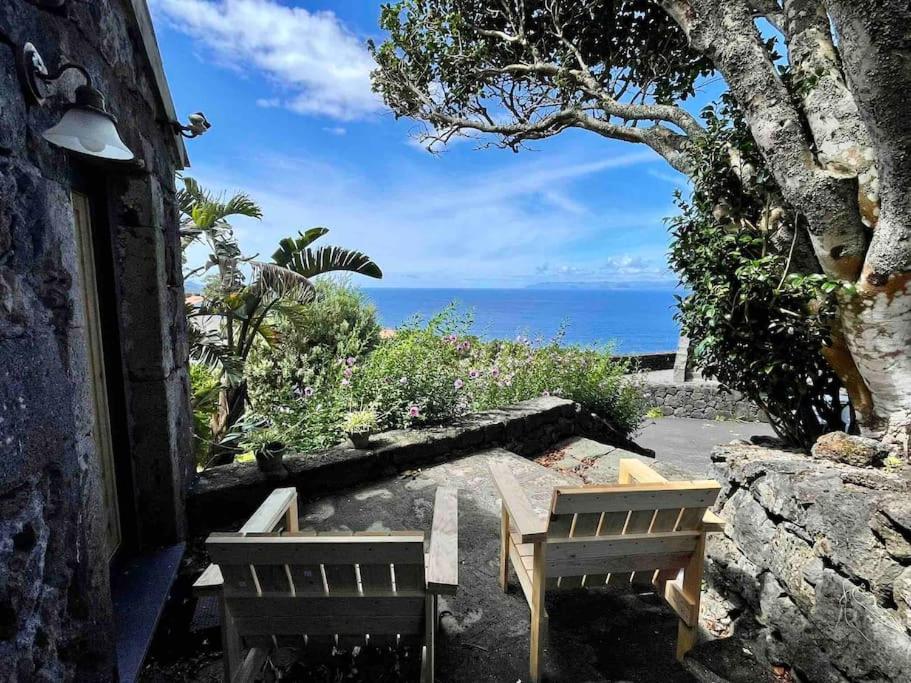 un patio con 2 sillas, una mesa y el océano en Casa do Laureano en Santo Amaro