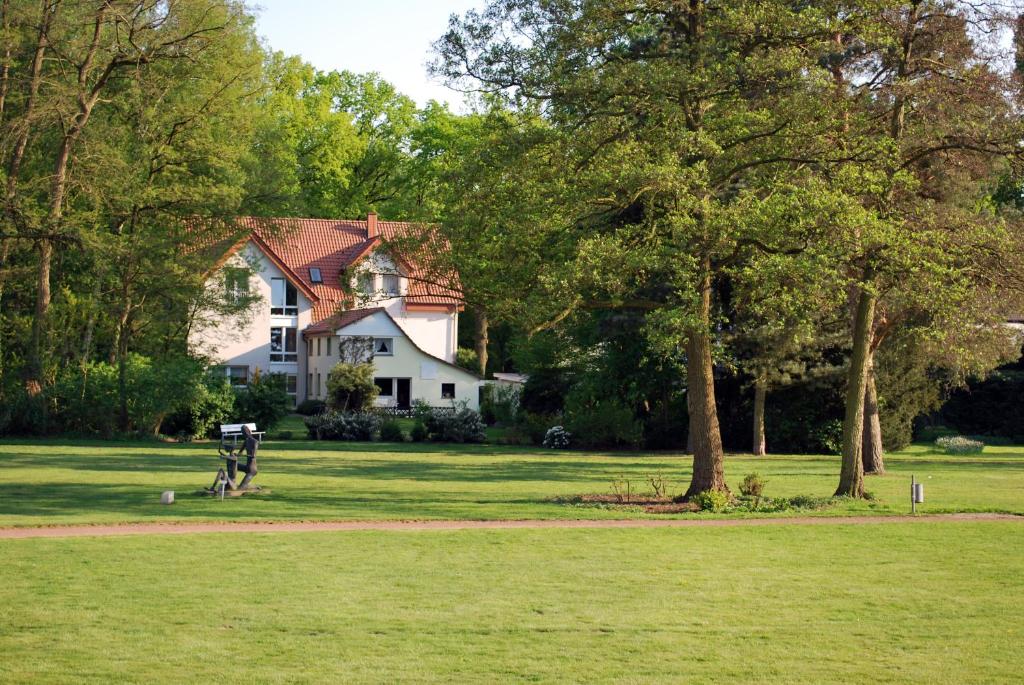 a white house with a tree in a field at Haus Geistmeier in Lippstadt
