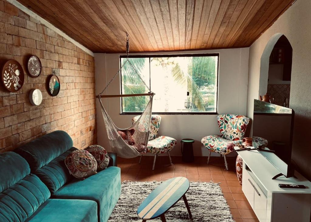 a living room with a blue couch and a hammock at Studio 1 casazul in Salvador