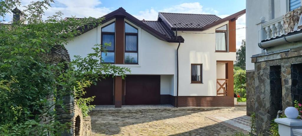 a white house with a brown garage at VillaMaria in Morshin