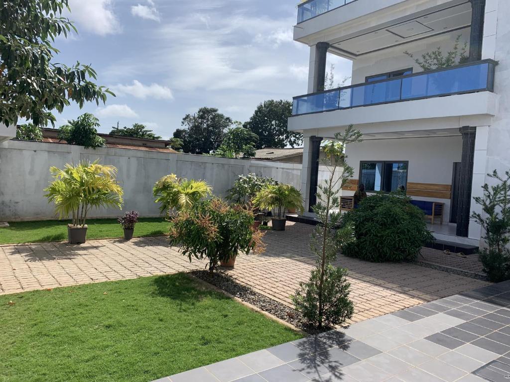 a house with a courtyard with plants and a fence at GUEST HOUSE ILÉ-IFÈ in Ouidah