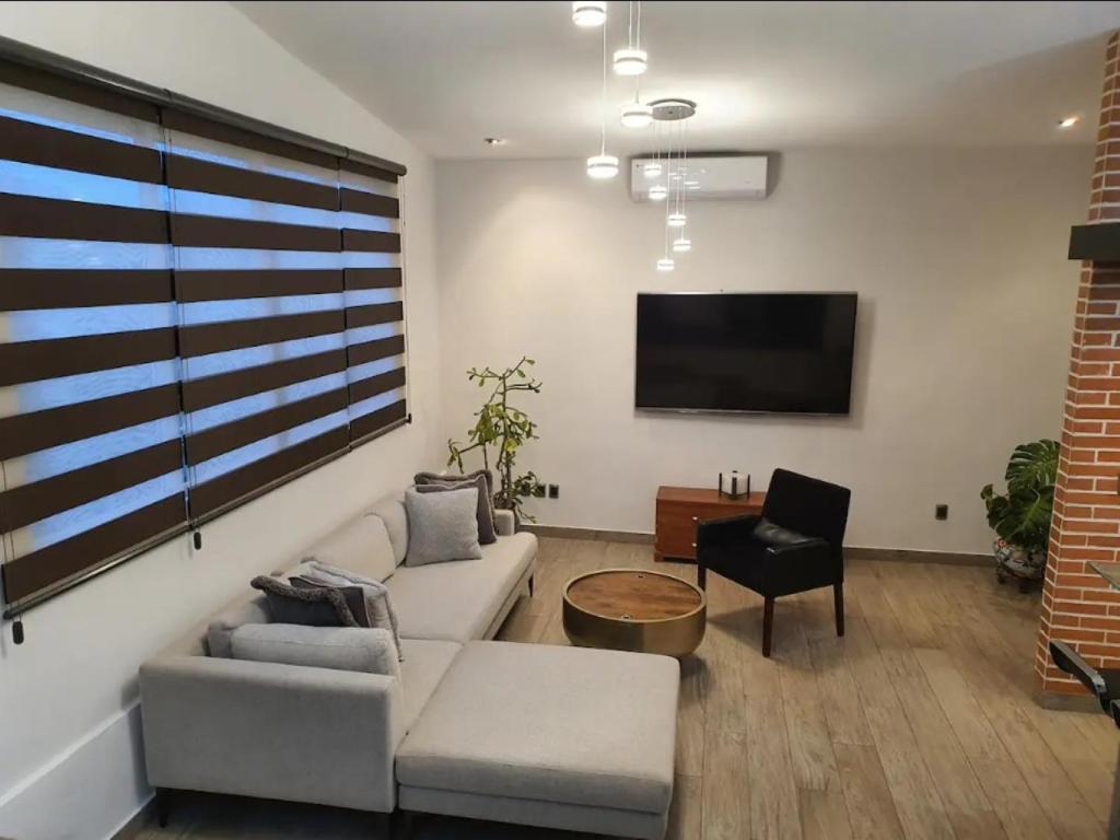 sala de estar con sofá y TV en Loft de Raty en Veracruz