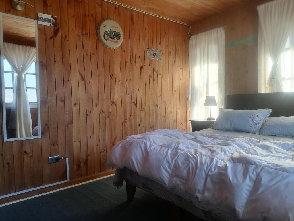 una camera con letto e parete in legno di Habitación Oda al Amor de la Estancia a El Quisco