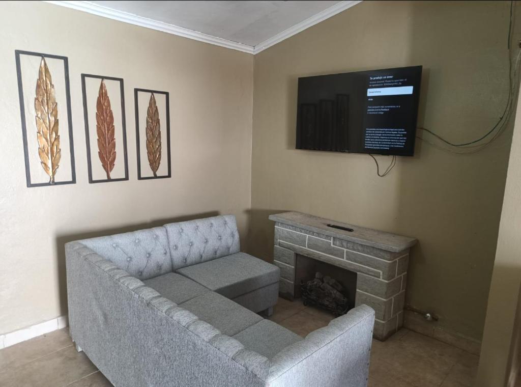 sala de estar con sofá y TV de pantalla plana en Casa la bendecida II en Santiago del Estero