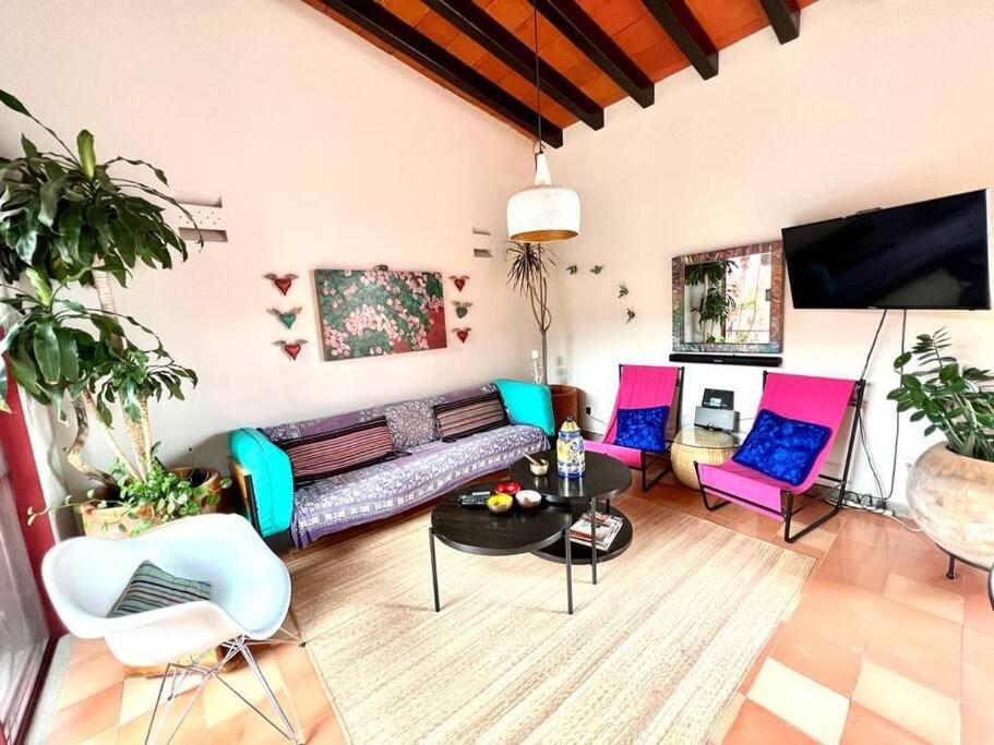 sala de estar con sillas coloridas y sofá en Casa Jacarandas, en Chapala