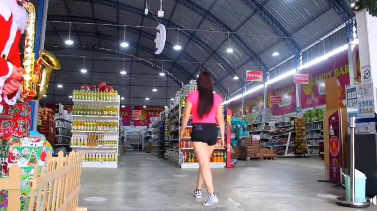 Una mujer caminando por el pasillo de una tienda de comestibles en MAHANAIMS, en Tingo María