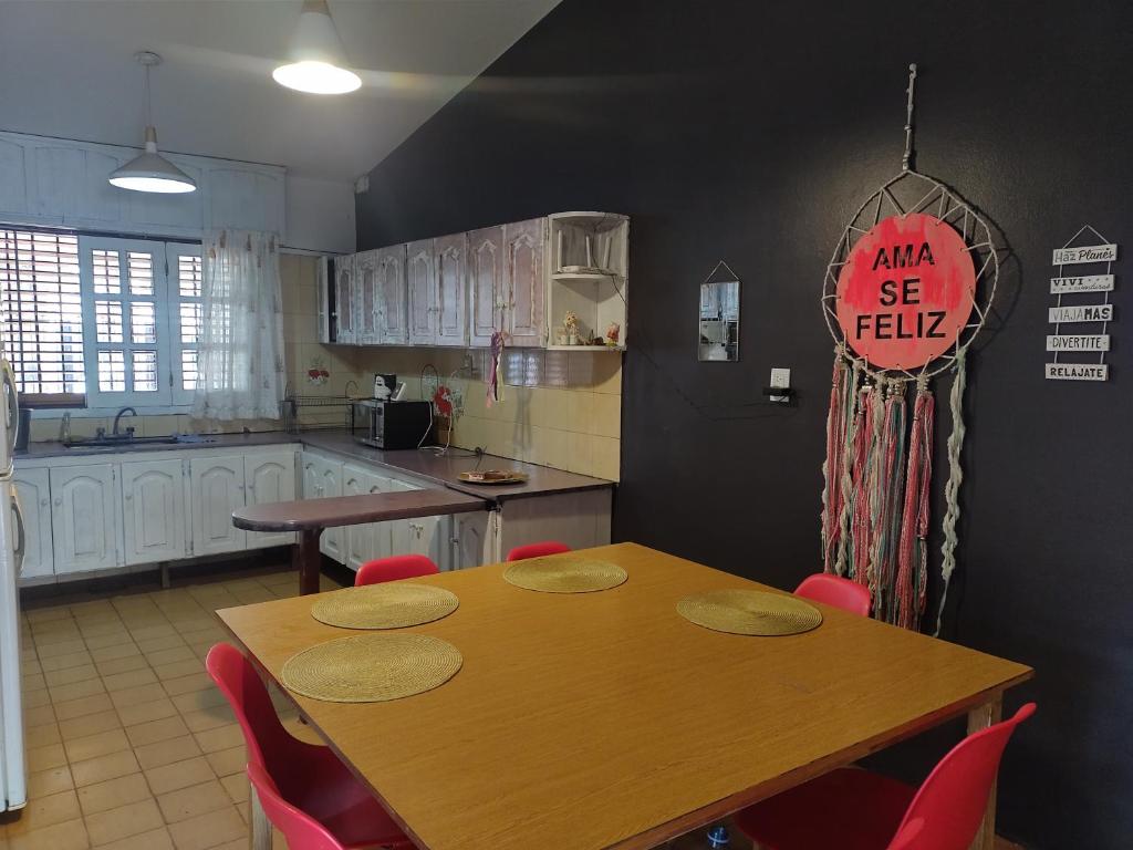 a kitchen with a wooden table and red chairs at Casa Grande pileta próximo kempes y aeropuerto Córdoba Capital in Córdoba