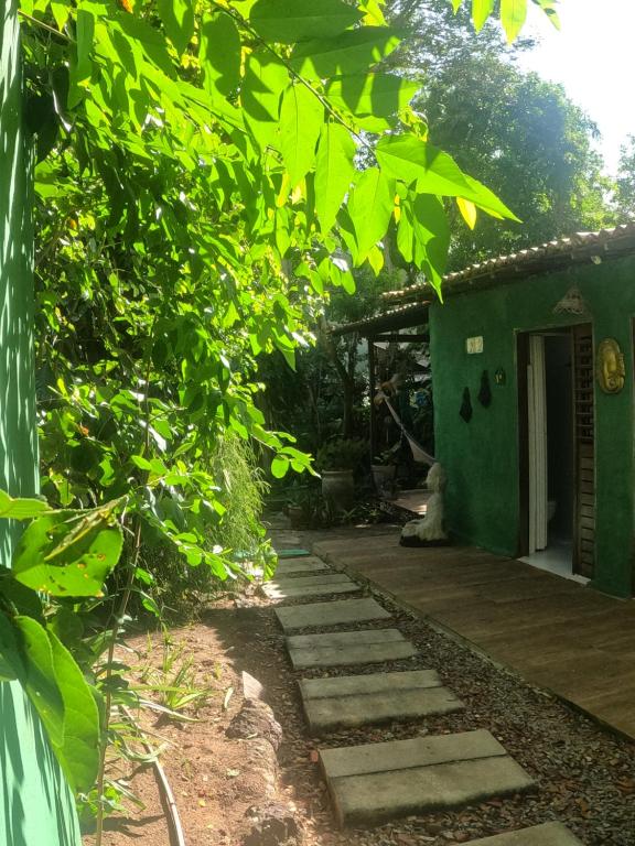 un camino de jardín que conduce a una casa verde en Recanto da Nara, en Pipa