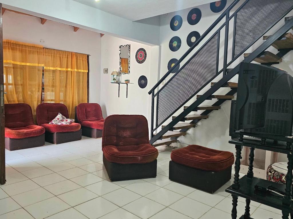 a waiting room with red chairs and a staircase at La joyita in Ituzaingó